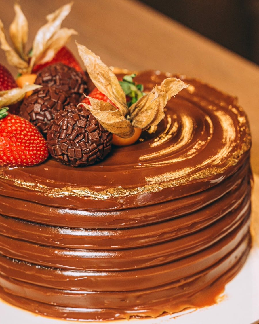 Torta de chocolate com folhas de ouro, brigadeiros e morangos da confeitaria Marquês