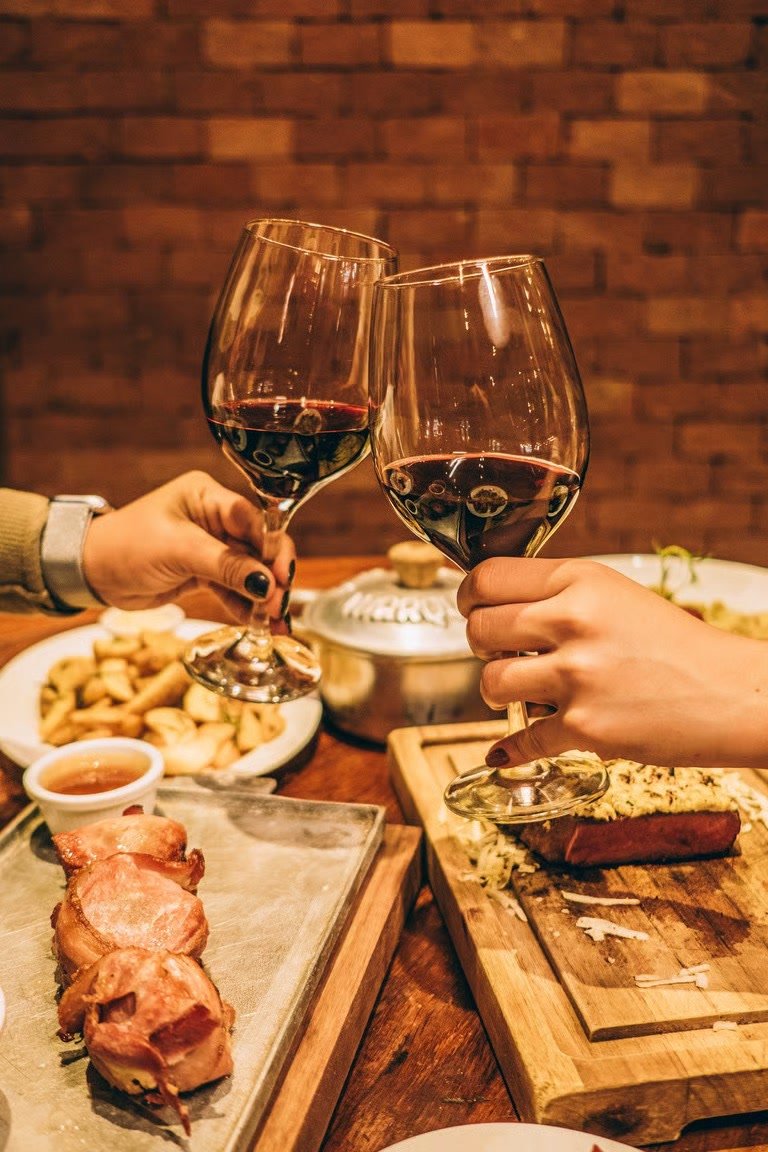 Brinde com taças de vinho tinto celebrando um momento especial